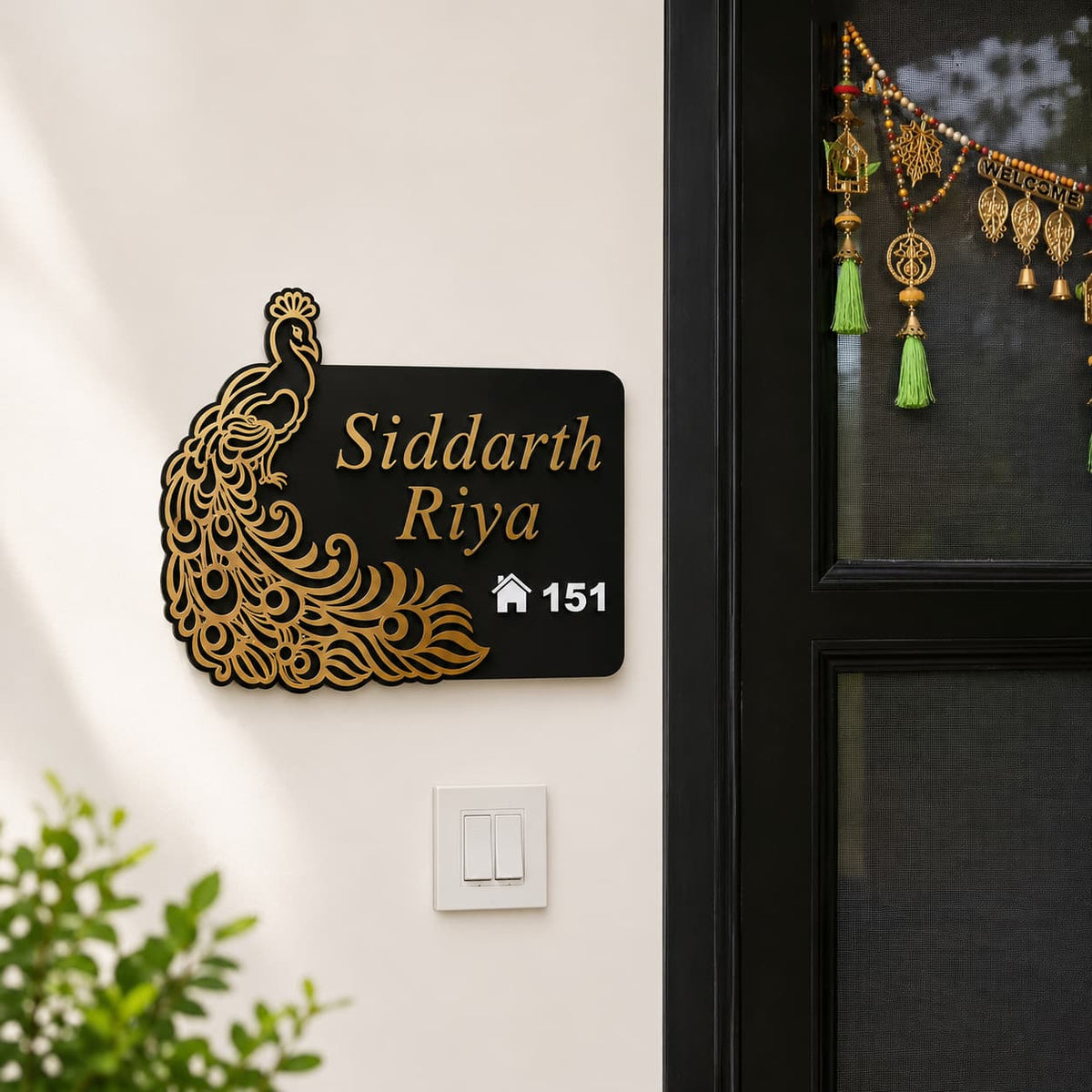 Premium peacock acrylic name plate installed on a modern home entrance wall with golden mirror design and custom family name.